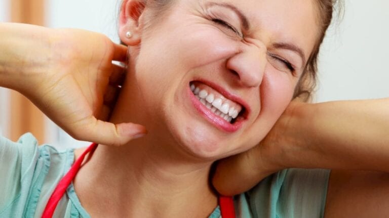 woman grabbing her neck in pain probably related to work injury