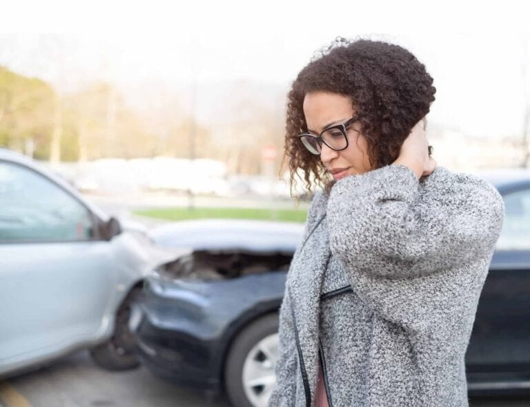 woman grabbing her neck after accident